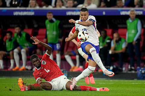Kevin Danso challenges for the ball with Kylian Mbappe